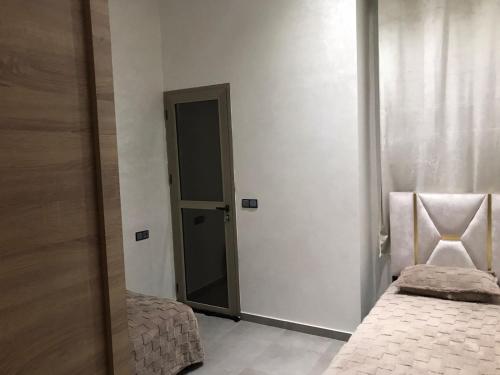a room with two beds and a door with a mirror at AM Atlas Home in Ifrane