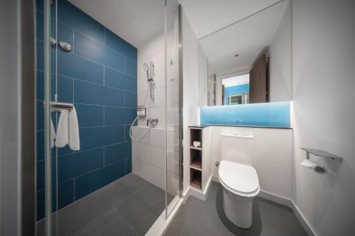 a bathroom with a toilet and a glass shower at Holiday Inn Express Zhengzhou Guancheng by IHG in Zhengzhou