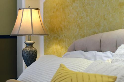 a bedroom with a bed with a lamp next to it at Hostal Villa Toscana in Guatemala