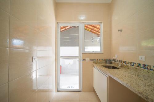 a bathroom with a shower and a sink and a window at Casa com piscina aquecida, Condomínio a beira mar in Bertioga