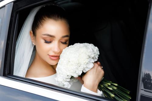 a bride in a car holding a bunch of flowers at InterContinental Seattle Bellevue, by IHG in Bellevue