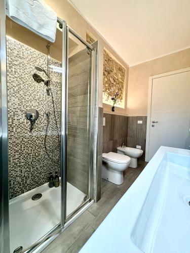 a bathroom with a tub and a toilet and a shower at Dimora di Charme Rooms & Apartments in Peschiera del Garda