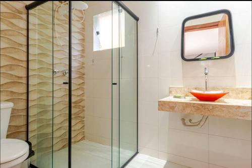 a bathroom with a glass shower and a sink at Espaço de festas e Hospedagem Cintia Lima in Betim