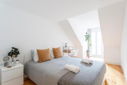 a white bedroom with a bed with towels on it at Suite in Cozy Apartment in Chiado in Shared House in Lisbon