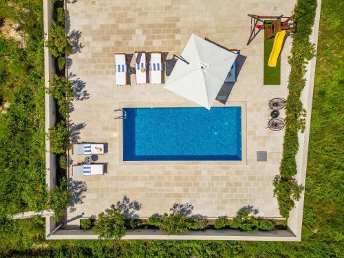 an overhead view of a swimming pool and an umbrella at House Villa Gold in Splitska