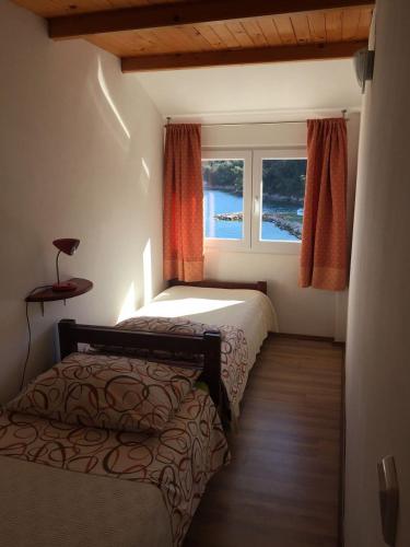 a bedroom with two beds and a window at Apartments Durda in Sali