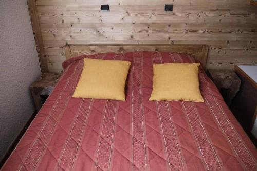 un lit avec deux oreillers dessus dans une chambre dans l'établissement Résidence Arpasson - ARPASSON 69 MAE-6291, à Les Allues