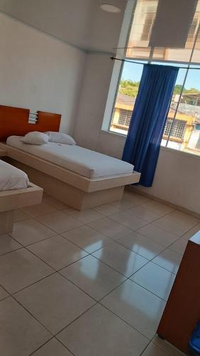 a bedroom with a bed and a large window at Hotel Ibiza in Armenia