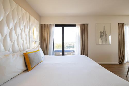 a bedroom with a large white bed and a window at Renaissance Aix-en-Provence Hotel in Aix-en-Provence