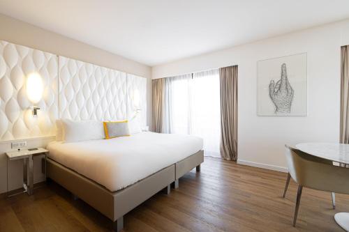 a hotel room with a large bed and a table at Renaissance Aix-en-Provence Hotel in Aix-en-Provence