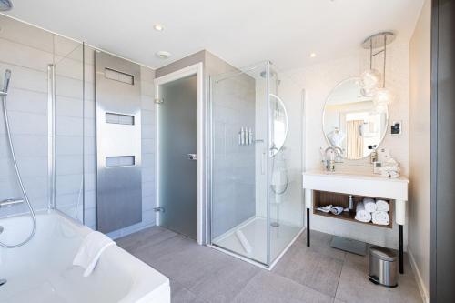 a bathroom with a shower and a tub and a sink at Renaissance Aix-en-Provence Hotel in Aix-en-Provence