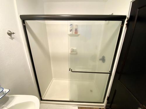 a shower with a glass door in a bathroom at Billie's Backpackers Hostel in Fairbanks