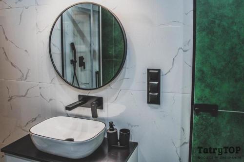 a bathroom with a sink and a mirror at TatryTop City Krupówki in Zakopane