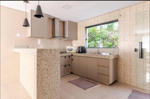 a kitchen with a sink and a window at Espaço de festas e Hospedagem Cintia Lima in Betim