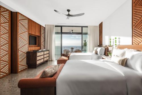 a hotel room with two beds and a television at Nekajui, a Ritz-Carlton Reserve in Papagayo, Guanacaste