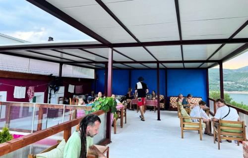 a group of people sitting on the deck of a restaurant at SuperPanorama GuestHouse in Kukës