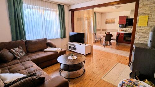 ヴィーク・アウフ・リューゲンにあるstayMA Strandhaus Wiek - Erholen Kitesurfen Wandern und Meerのソファとテーブルのあるリビングルーム