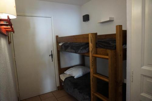 Cette chambre comprend 2 lits superposés et une porte. dans l'établissement Chalet D'orcieres - Studio cabine 4 personnes MAE-2754, à Orcières