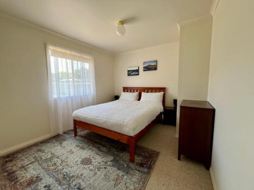 a bedroom with a bed and a window at Promhills Cabins in Yanakie