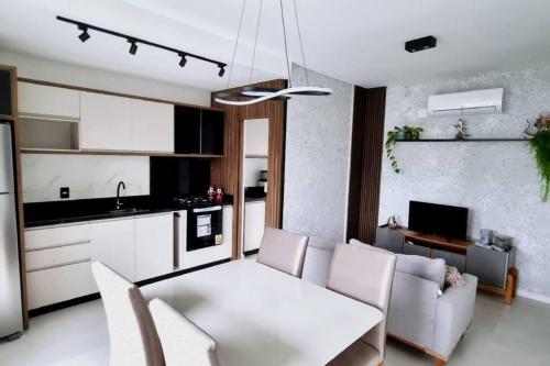 a kitchen and living room with a white table and chairs at APTO NOVO - Praias, Beto Carrero e Aeroporto in Navegantes