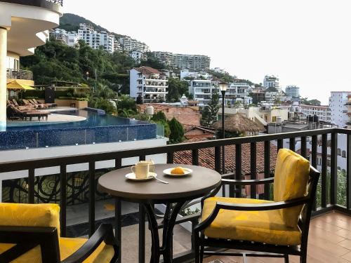a table and chairs on a balcony with a view at Pinnacle Resorts 179 - Adults Only in Puerto Vallarta