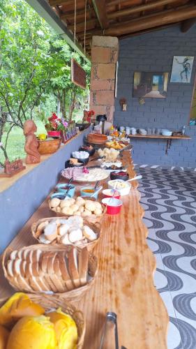 a long table with many plates of food on it at Pousada Jardim Lençóis in Lençóis