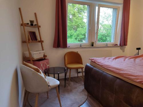 Un dormitorio con una cama y dos sillas y una mesa. en Ferien-Appartements am Rödertor, en Rothenburg ob der Tauber