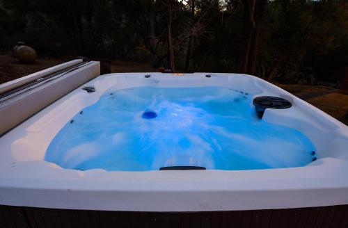 a jacuzzi tub with blue water in it at Luxury Lodge-Hot Tub-BBQ-Sleeps 18 in Oakhurst