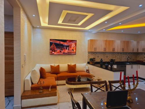 a living room with a couch and a kitchen at Azur appartement essaouira in Essaouira