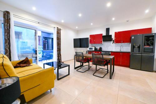 un salon avec un canapé jaune et une cuisine avec des placards rouges dans l'établissement Grand loft à deux pas de la mer n1, à Nice