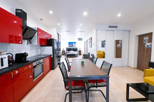 une cuisine avec des armoires rouges et une table et des chaises dans l'établissement Grand loft à deux pas de la mer n1, à Nice