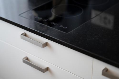a black microwave oven sitting on top of a kitchen drawer at Amanthos Living Solothurn in Grenchen