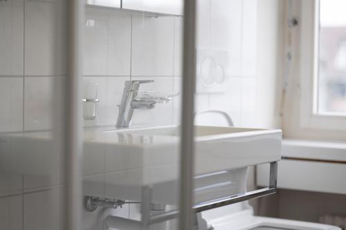 a bathroom with a white sink and a mirror at Amanthos Living Solothurn in Grenchen