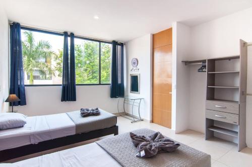 a bedroom with two beds and a large window at Paraíso Casa Turquesa Playa del Carmen in Playa del Carmen