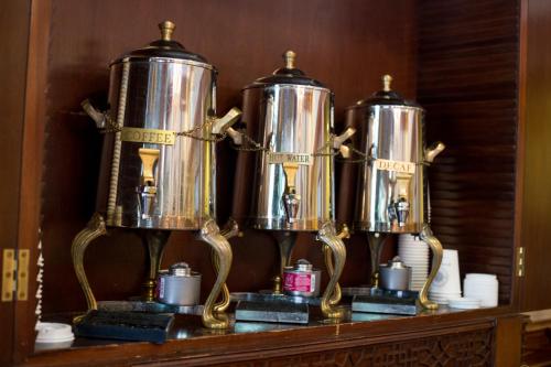 three metal kettles on top of a shelf at River Street Inn in Savannah