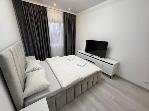 a hotel room with a bed and a television at Cataleya Suites Apartament's in Bucharest