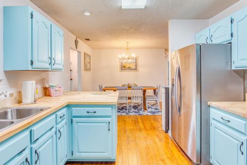 a kitchen with blue cabinets and a stainless steel refrigerator at 3 Mi to Ocean Home with Deck in Little River! in Little River