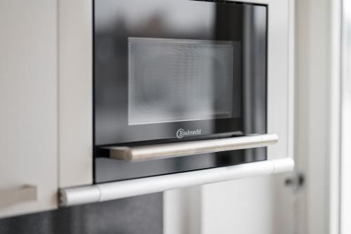 a flat screen tv sitting inside of a door at Amanthos Living Solothurn in Grenchen