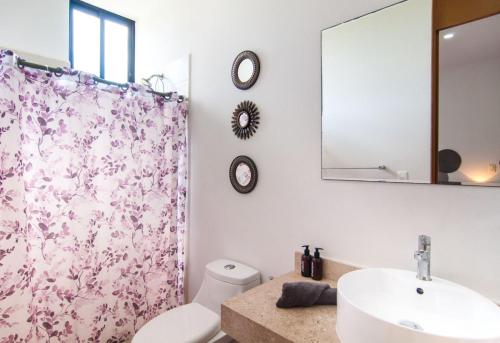 a bathroom with a sink and a toilet and a mirror at Paraíso Casa Turquesa Playa del Carmen in Playa del Carmen
