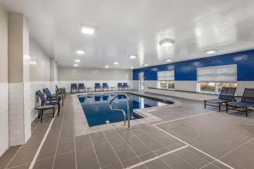 a swimming pool in a building with chairs and a table at Country Inn & Suites by Radisson Bolingbrook, I-55 in Bolingbrook