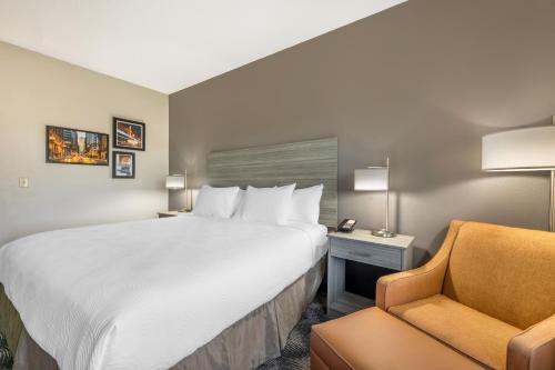 a hotel room with a large bed and a chair at Country Inn & Suites by Radisson Bolingbrook, I-55 in Bolingbrook