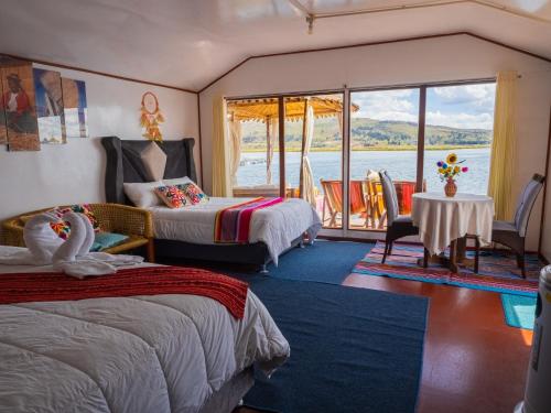 a bedroom with two beds and a view of the water at TITICACA ISLAND LODGe in Puno