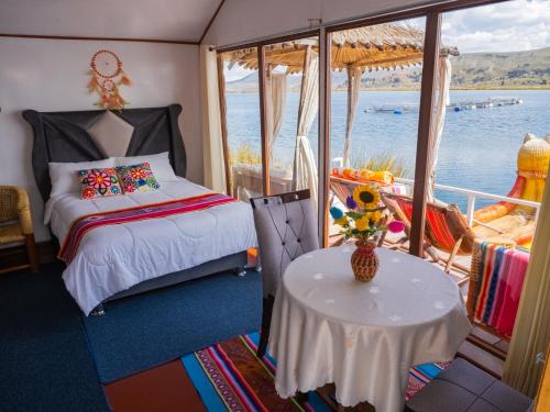 a room with a bed and a table on a boat at TITICACA ISLAND LODGe in Puno