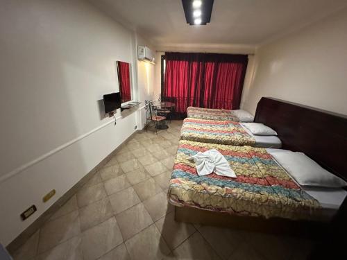 a hotel room with two beds and a television at Arabesque Hotel in Cairo