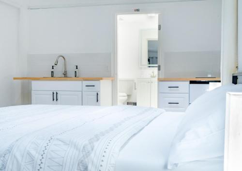 a white kitchen with white cabinets and a white bed at Cozy apartment near Busch Gardens Adventure Island and USF in Tampa