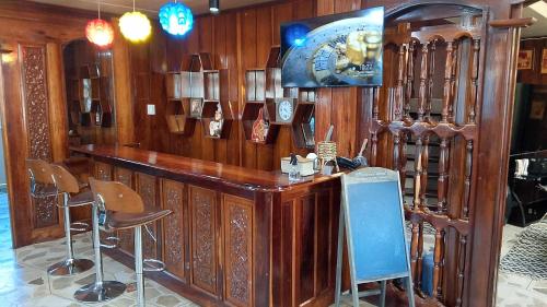a bar in a room with wooden walls and stools at Topaz Bed & Breakfast Hotel in San Jose