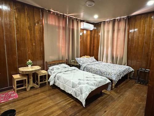 a bedroom with two beds and a table in it at Topaz Bed & Breakfast Hotel in San Jose