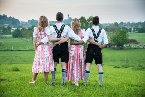 a group of four people standing in a field at Boutique Hotel POST ANDECHS in Andechs