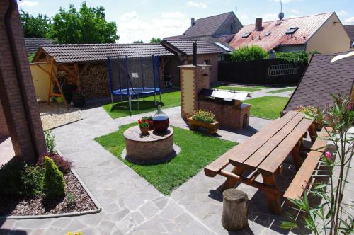 a backyard with a wooden bench and a playground at Ubytování a apartmány Sluníčko in Lomnice nad Lužnicí