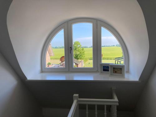 an arched window with a view of a field at Jette in Mellnitz